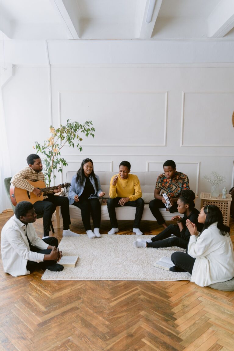 A group of adults singing and playing music together indoors.
