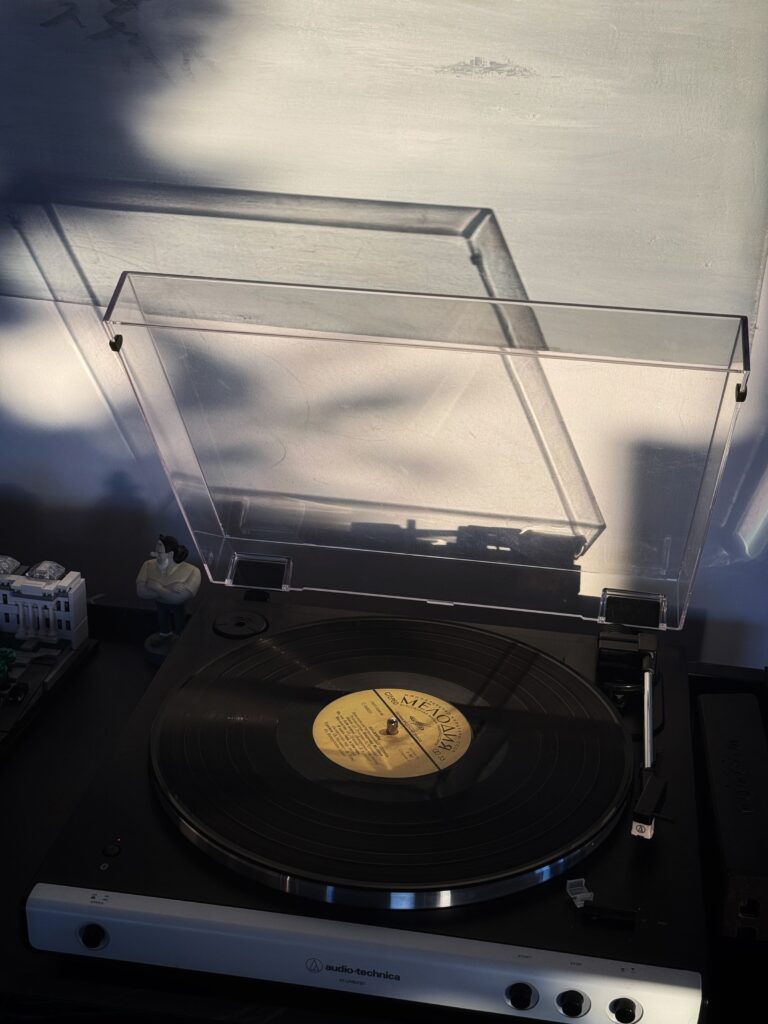 A turntable and vinyl record in soft sunlight.